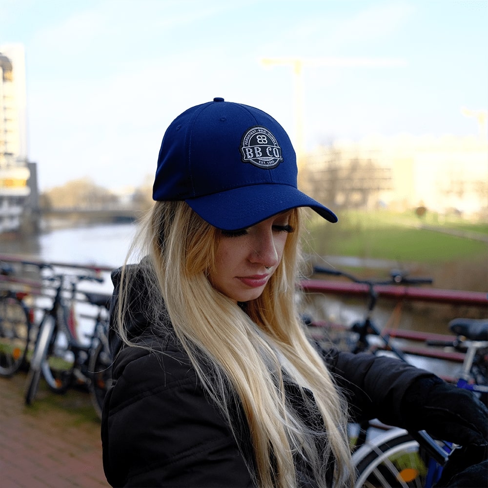 Junge Frau mit blonden Haaren trägt die oversize BigBrains Baseball Cap.